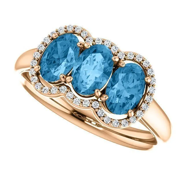 14KT GOLD 1.74 CTW BLUE TOPAZ & .10 CTW DIAMOND 3 STONE OVAL HALO RING