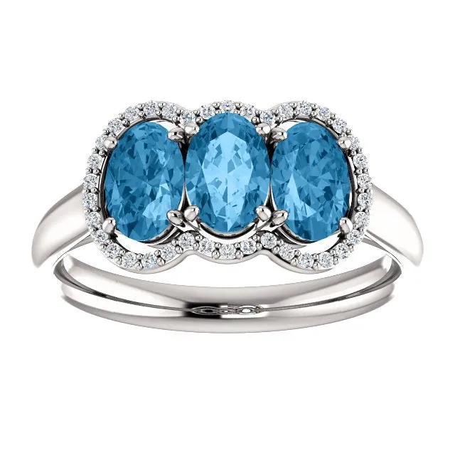 14KT GOLD 1.74 CTW BLUE TOPAZ & .10 CTW DIAMOND 3 STONE OVAL HALO RING