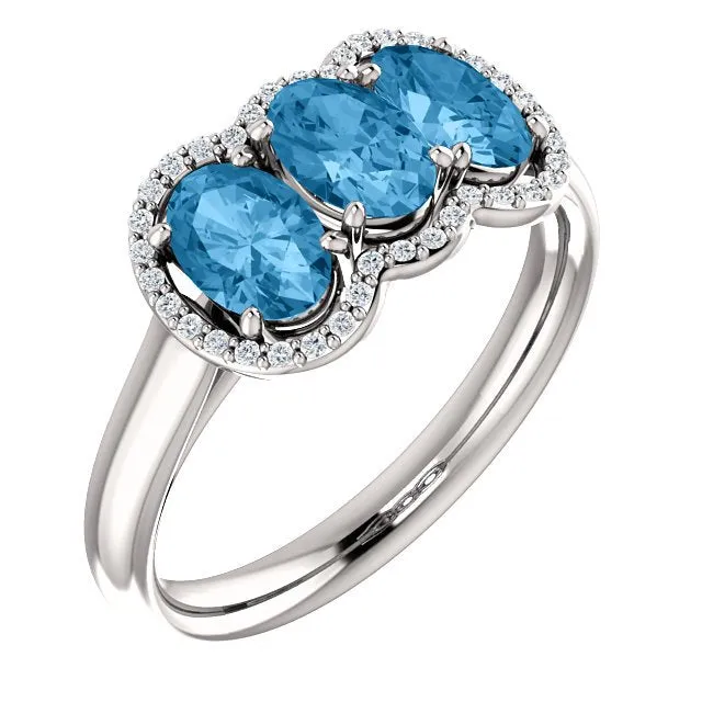 14KT GOLD 1.74 CTW BLUE TOPAZ & .10 CTW DIAMOND 3 STONE OVAL HALO RING